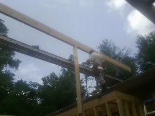 Carpenter setting a ridge beam over a new addition frame — Ice Dam Removal by Roofing Brothers in Lennox