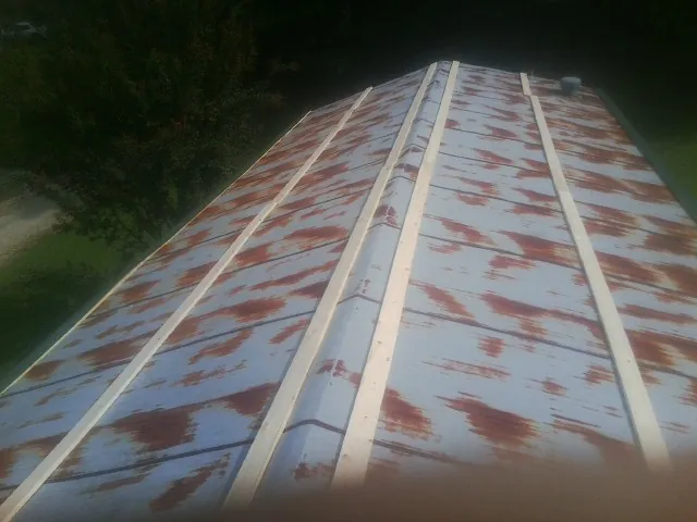 Rusted metal roof panels with new wood purlins before replacement — Storm Damage Roof Repair in Lennox by Roofing Brothers
